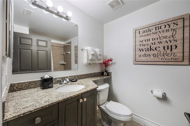full bathroom featuring a tile shower, visible vents, toilet, and vanity