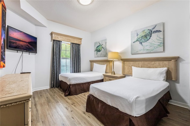 bedroom featuring baseboards and wood finished floors