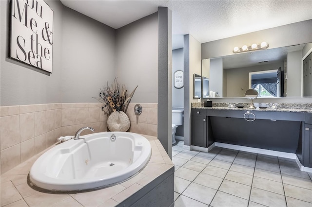 full bathroom featuring tile patterned floors, vanity, a tub with jets, and toilet