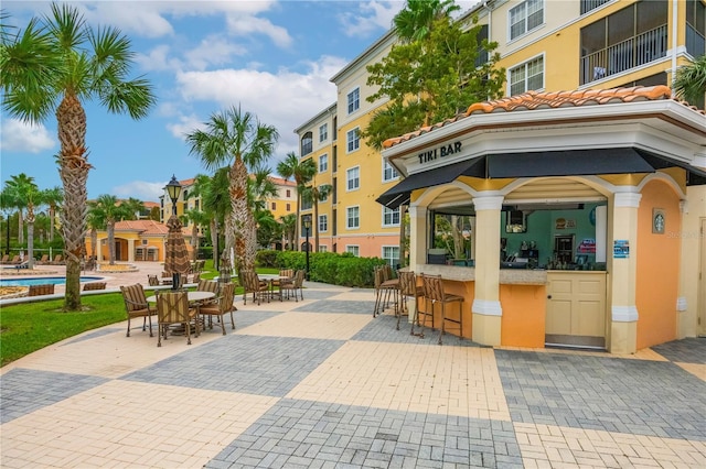 surrounding community with outdoor dry bar, a gazebo, a patio, and a swimming pool