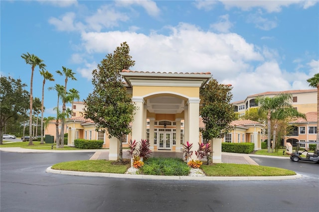 exterior space with french doors, a tiled roof, and stucco siding