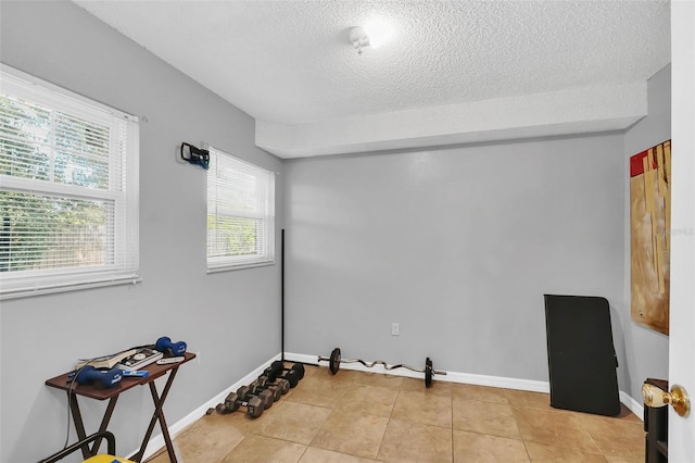 unfurnished room with light tile patterned flooring and a textured ceiling