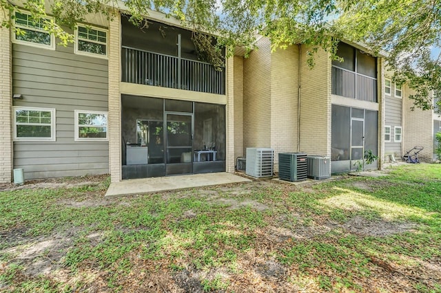 rear view of house with a sunroom and central AC unit