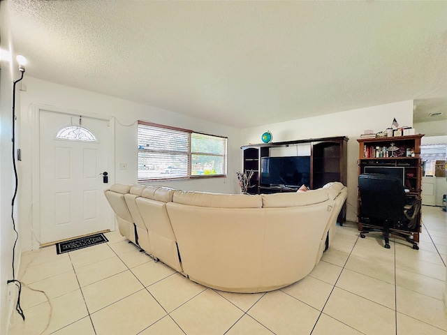 tiled living room featuring a textured ceiling