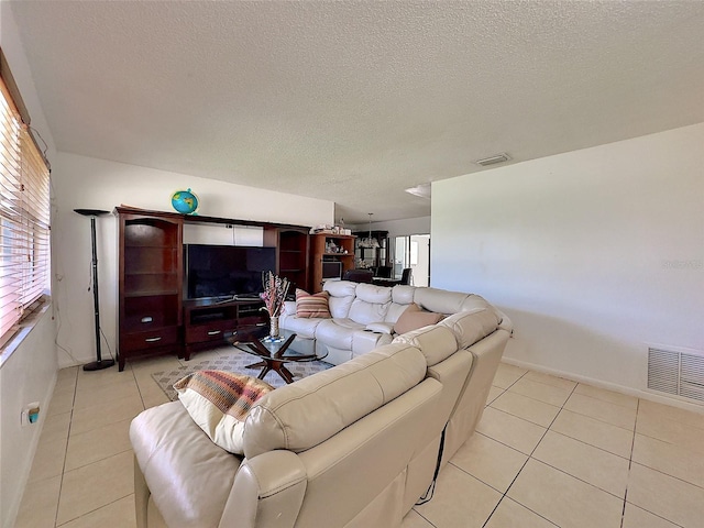 tiled living room featuring a textured ceiling