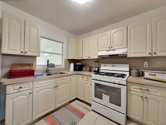 kitchen with white range with gas stovetop, sink, and light tile patterned floors