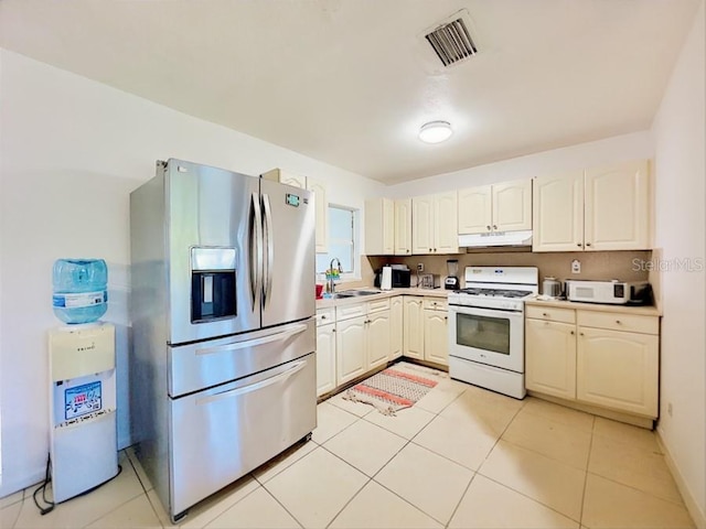 kitchen featuring white appliances, sink, and light tile patterned floors