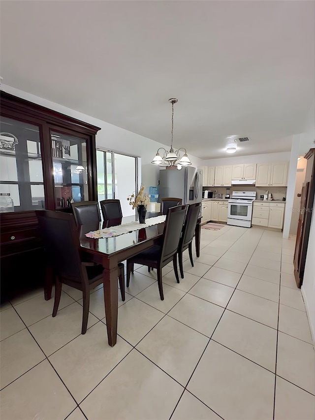 tiled dining room featuring a notable chandelier