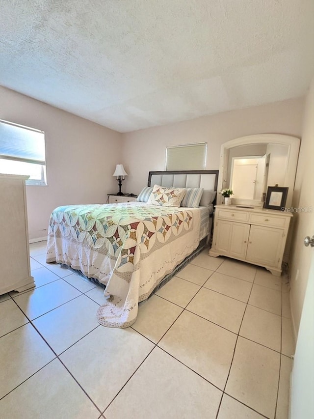 tiled bedroom with a textured ceiling