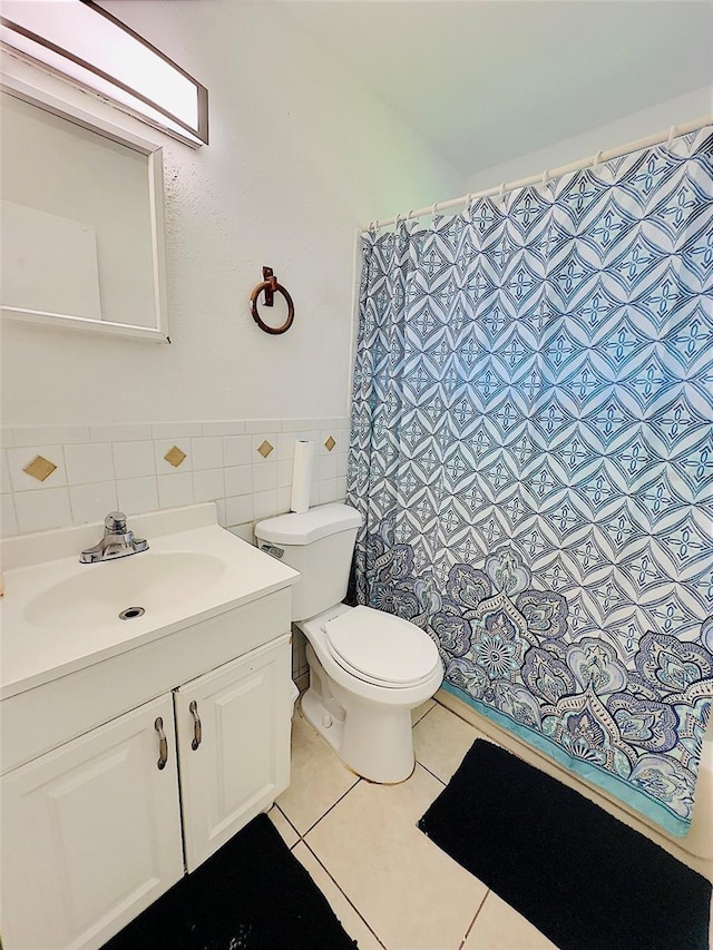 bathroom featuring vanity, toilet, a shower with curtain, tile walls, and tile patterned flooring