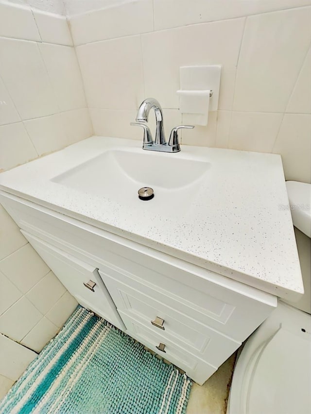 bathroom with vanity and tile walls