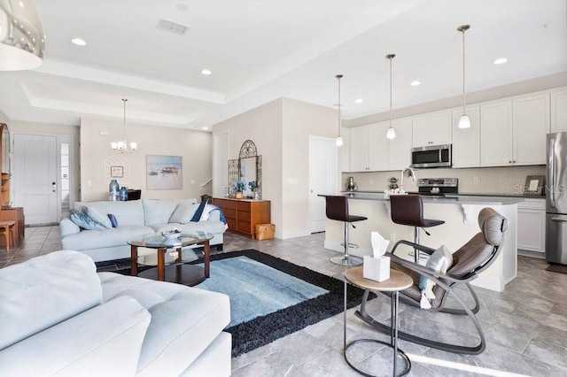 593 Lake Wildmere Cv, Longwood, FL 32750 - living room featuring a chandelier, recessed lighting, baseboards, and a tray ceiling