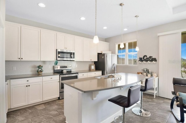 593 Lake Wildmere Cv, Longwood, FL 32750 - kitchen featuring appliances with stainless steel finishes, an island with sink, backsplash, white cabinets, and recessed lighting