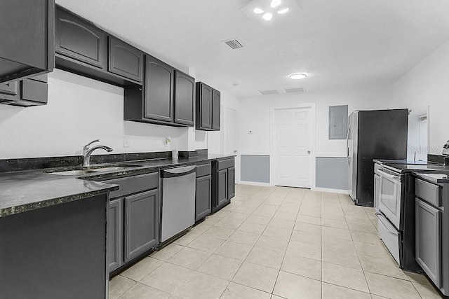 kitchen with sink, dishwasher, dark stone countertops, electric stove, and light tile patterned floors