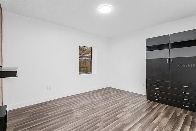 unfurnished bedroom with hardwood / wood-style floors, a textured ceiling, and a closet