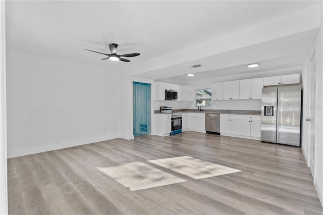 kitchen with light hardwood / wood-style floors, white cabinetry, and stainless steel appliances