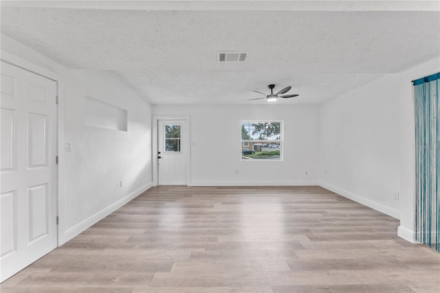 unfurnished room with a textured ceiling, light hardwood / wood-style floors, and ceiling fan