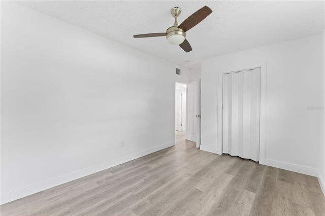 unfurnished room with light hardwood / wood-style flooring, a textured ceiling, and ceiling fan