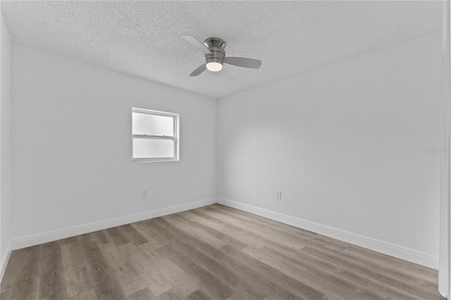 spare room with a textured ceiling, light hardwood / wood-style floors, and ceiling fan