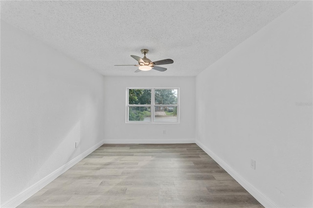 spare room with ceiling fan, a textured ceiling, and light hardwood / wood-style flooring