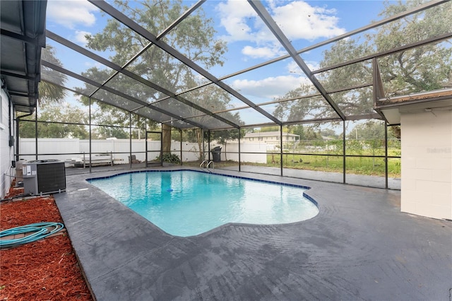 view of swimming pool with central AC, a patio, and glass enclosure