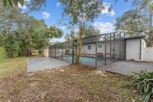 rear view of house featuring a fenced in pool, a lanai, and a patio