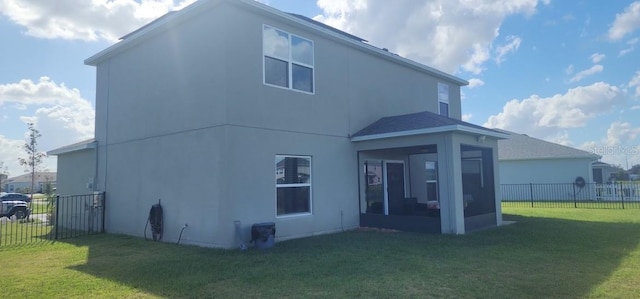 back of house with a sunroom and a lawn