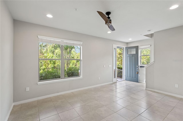 empty room with ceiling fan and light tile patterned floors