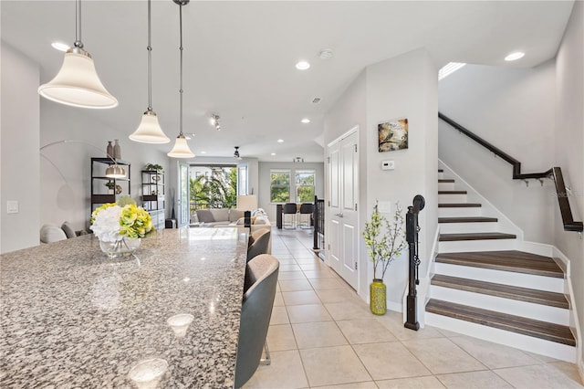 594 Piazza Pt, Oviedo, FL 32765 - kitchen featuring light tile patterned floors, stone counters, recessed lighting, pendant lighting, and open floor plan