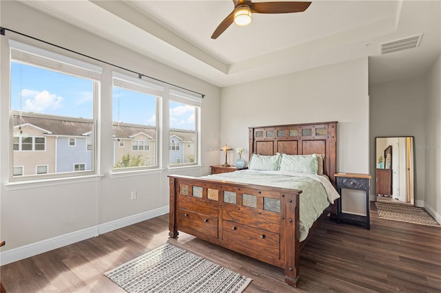 bedroom featuring ceiling fan, dark hardwood / wood-style flooring, and multiple windows