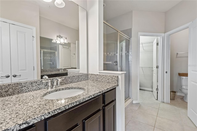 bathroom with toilet, tile patterned floors, vanity, and an enclosed shower