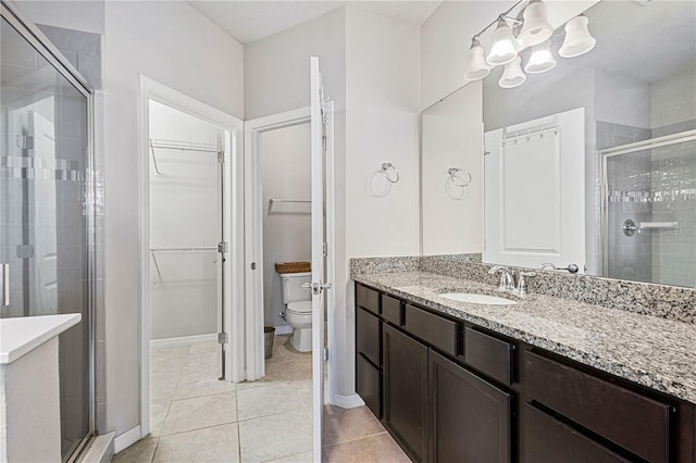 594 Piazza Pt, Oviedo, FL 32765 - bathroom with a shower stall, a walk in closet, a chandelier, toilet, and tile patterned floors