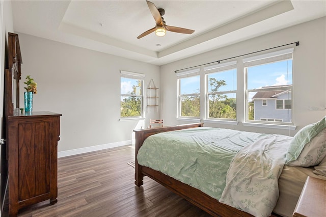 594 Piazza Pt, Oviedo, FL 32765 - bedroom featuring a tray ceiling, baseboards, wood finished floors, and ceiling fan
