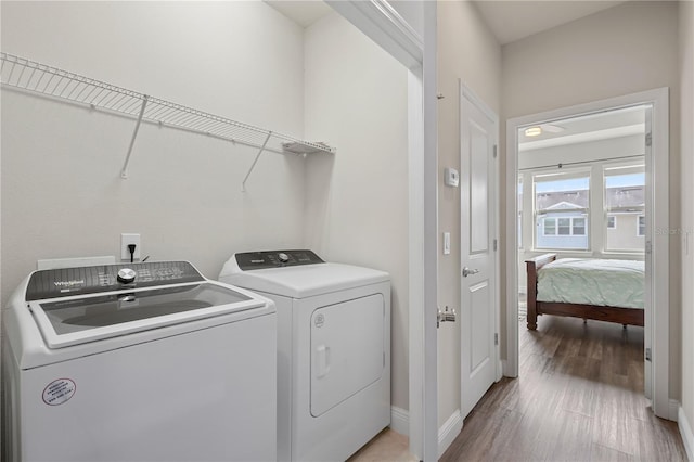 clothes washing area featuring light wood-type flooring and washing machine and clothes dryer