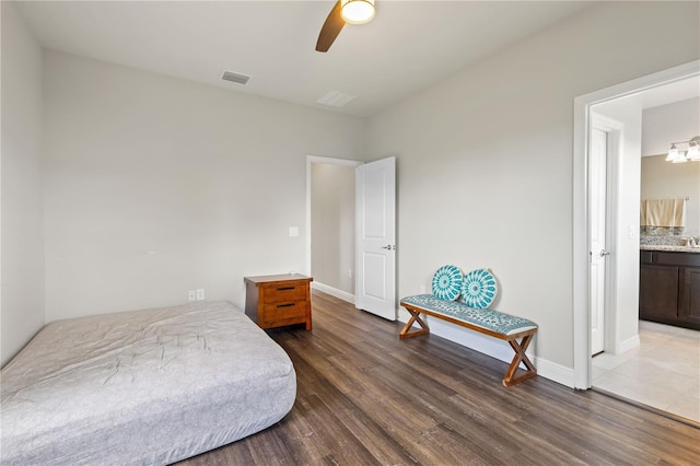 bedroom featuring hardwood / wood-style floors, ensuite bathroom, and ceiling fan