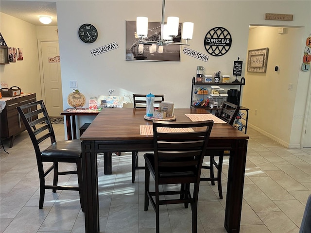 dining area featuring a notable chandelier and light tile patterned flooring