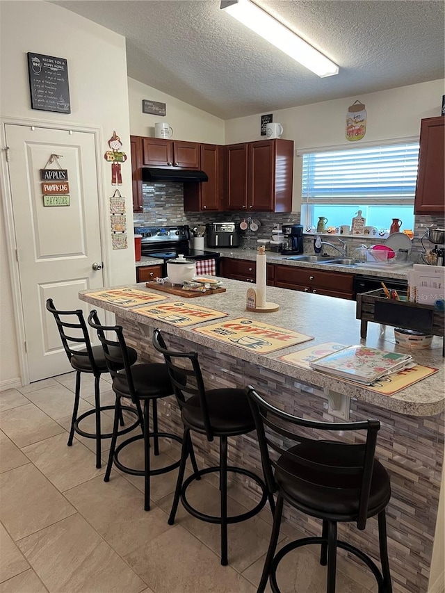 kitchen featuring backsplash, vaulted ceiling, light tile patterned floors, a textured ceiling, and electric stove