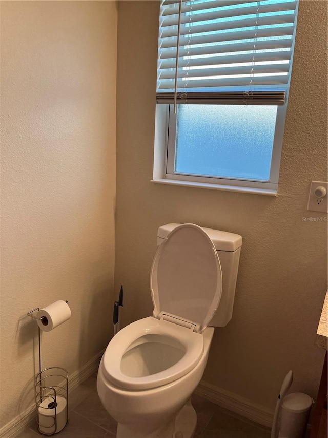 bathroom with toilet and tile patterned flooring