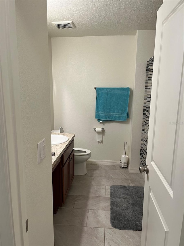 bathroom with vanity, toilet, a textured ceiling, and a shower with shower curtain