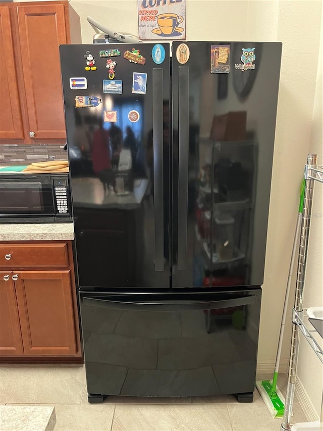 kitchen featuring black appliances, tasteful backsplash, and light tile patterned floors