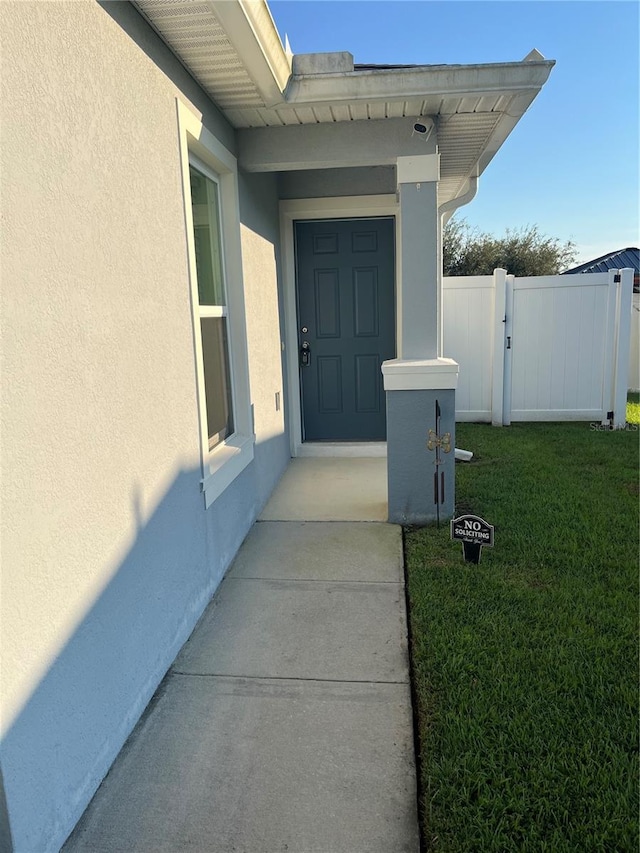 entrance to property with a lawn