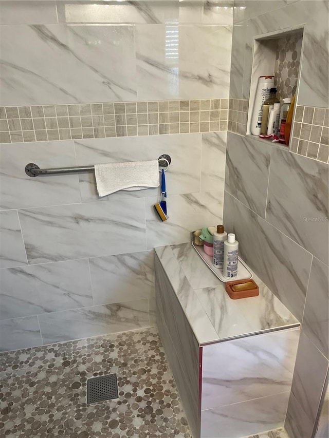 bathroom featuring tile walls and tiled shower