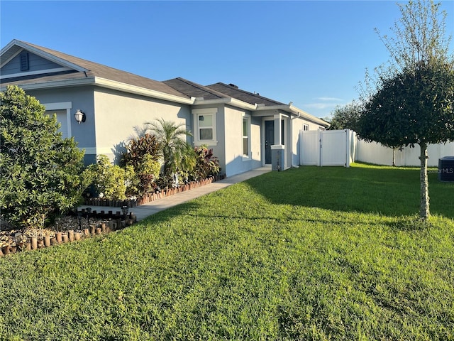 view of front of home featuring cooling unit and a front lawn