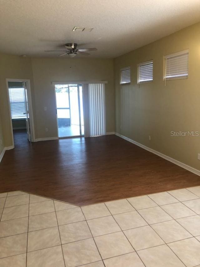 empty room with a textured ceiling, light hardwood / wood-style floors, and ceiling fan