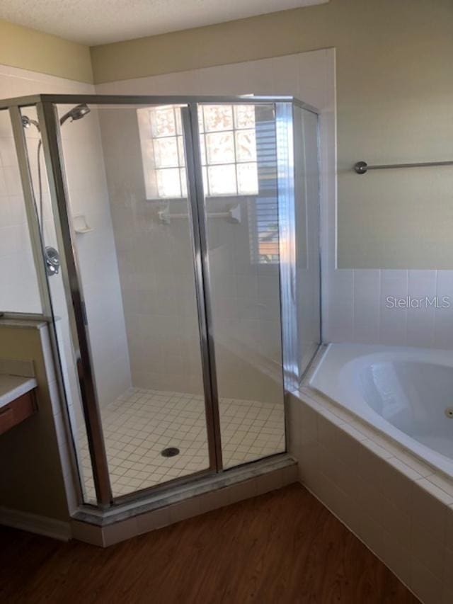 bathroom with hardwood / wood-style floors and plus walk in shower