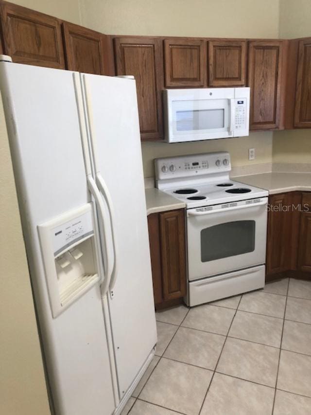 kitchen with white appliances and light tile patterned floors