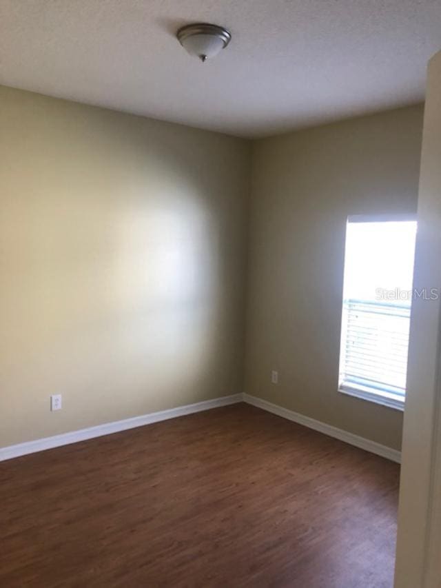 empty room featuring dark hardwood / wood-style flooring