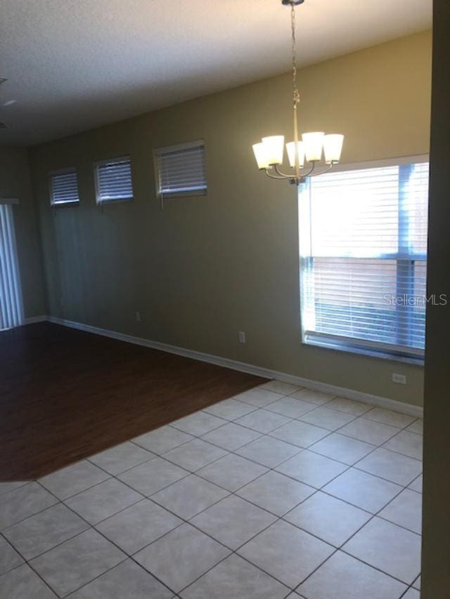 empty room featuring light hardwood / wood-style flooring and an inviting chandelier