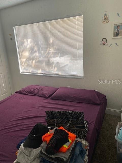 bedroom featuring carpet floors and baseboards