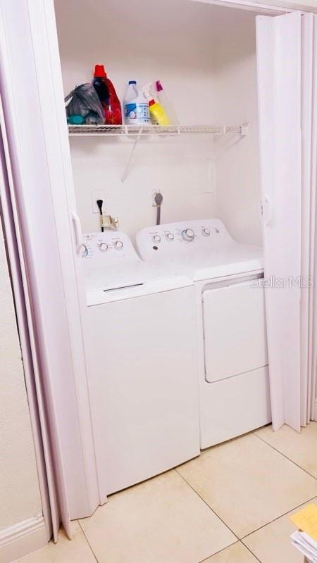 laundry area with light tile patterned floors and independent washer and dryer